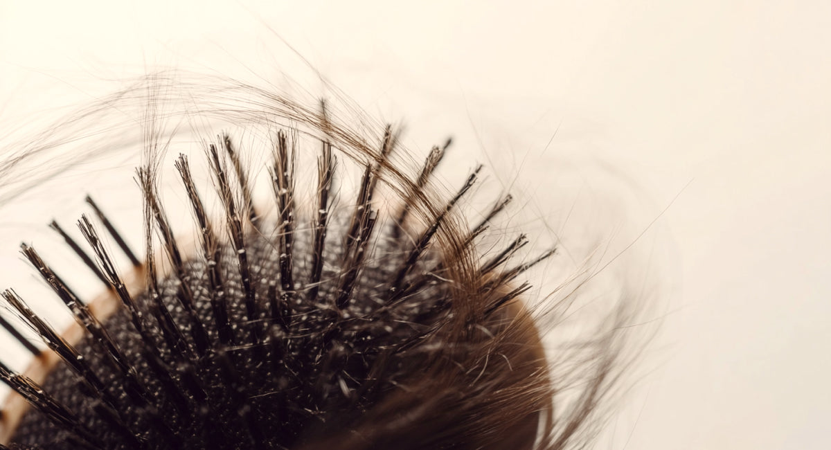 Woman with thinning hair examining her reflection in a mirror.